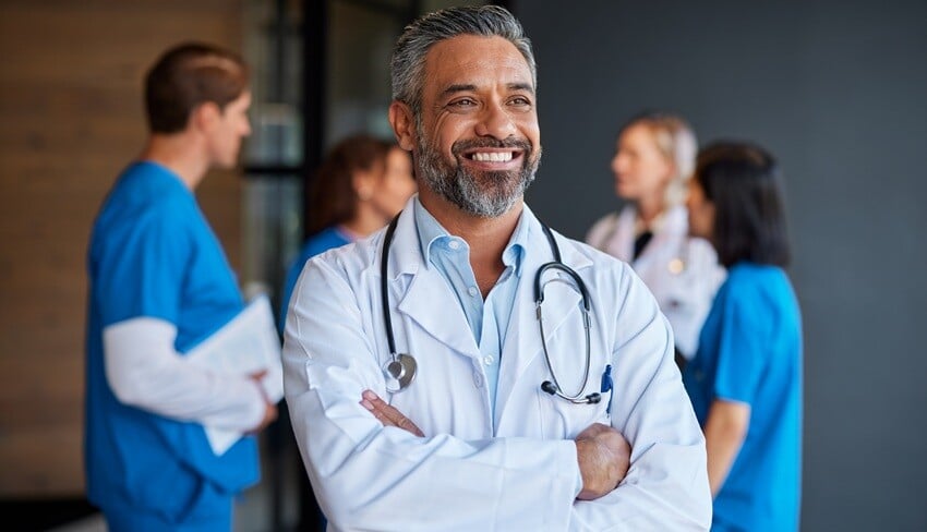 smiling-middle-aged-indian-doctor-thinking-and-loo-2025-01-10-04-29-37-utc